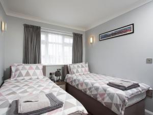 a bedroom with two beds next to a window at Northwood 2 in Broadstairs +5 photos