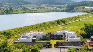 an aerial view of a house on a hill next to a lake at Buan Cordelia Pool Villa Pension in Buan