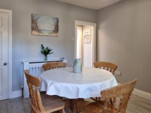 a dining room with a table with chairs and a vase on it at Curlew Cottage- Ukc5450 in Pakefield