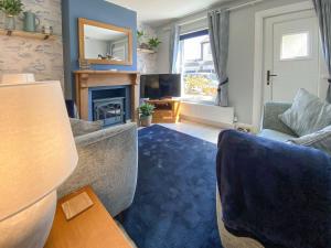 a living room with a couch and a fireplace at Curlew Cottage- Ukc5450 in Pakefield