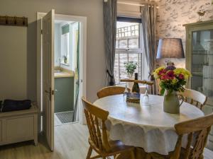 a dining room table with a vase of flowers on it at Curlew Cottage- Ukc5450 in Pakefield
