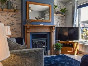 a living room with a fireplace and a mirror at Curlew Cottage- Ukc5450 in Pakefield