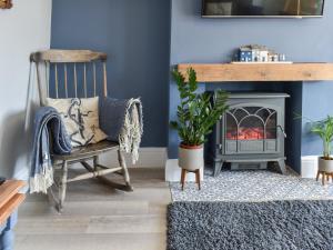 a living room with a chair and a fireplace at Avocet - Ukc5446 in Pakefield