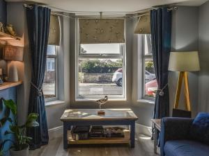 a living room with two windows with blue curtains at Avocet - Ukc5446 in Pakefield