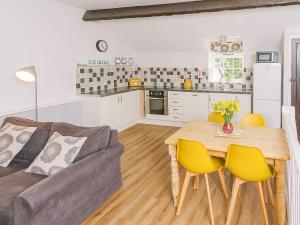 a living room with a couch and a table with yellow chairs at Number Two - Ukc4964 in Tawstock