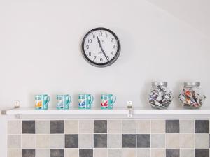 a clock on a white wall above a shelf with vases at Number Two - Ukc4964 in Tawstock