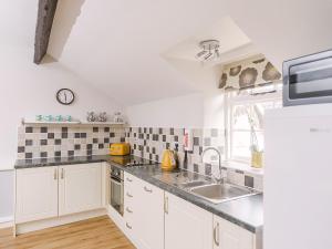 a kitchen with white cabinets and a sink at Number Two - Ukc4964 in Tawstock