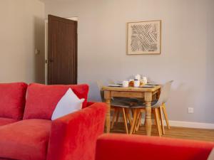 a living room with a red couch and a table at Number Four - Ukc4966 in Tawstock
