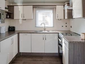 a kitchen with white cabinets and a sink at Jessie's Corner - Ukc5509 in West Thirston