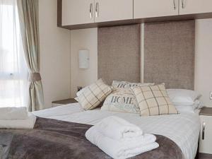 a bedroom with a large bed with towels on it at Jessie's Corner - Ukc5509 in West Thirston +2 photos