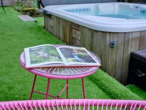 a book on a pink table in the grass next to a tub at The Den - Ukc4937 in West Anstey +6 photos