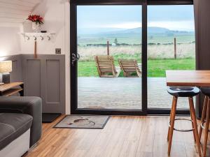 a living room with a sliding glass door with a table and chairs at Knockan - Ukc6026 in Newmill