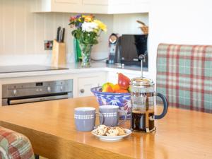 a table with two cups of coffee and a bowl of fruit at The Golf Place in St. Andrews +11 photos