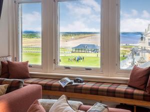 a living room with a large window with a view of a beach at The Golf Place in St. Andrews