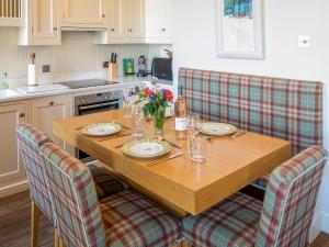 a kitchen with a wooden table and chairs with flowers at The Golf Place in St. Andrews