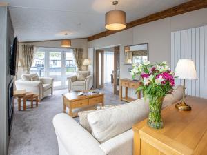 a living room with a couch and a vase of flowers at Rivendale 7 in St. Andrews
