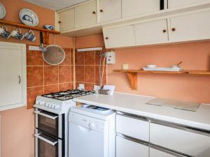 a kitchen with a stove and a white stove top oven at Grove Cottage in Yarmouth