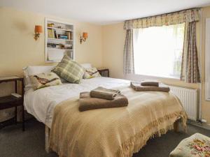 a bedroom with a bed with two towels on it at Grove Cottage in Yarmouth +10 photos