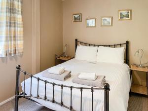 a bedroom with a bed with towels on it at Crianlarich Cottage in Fort Augustus