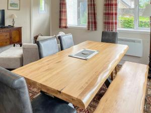 a wooden table in a living room with chairs at Crianlarich Cottage in Fort Augustus