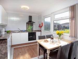 a kitchen with a table and a dining room at 310 The Cove - Ukc5025 in Dawlish