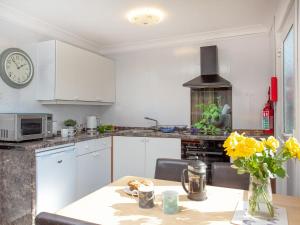 a kitchen with a table and a clock on the wall at 310 The Cove - Ukc5025 in Dawlish +11 photos