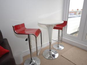 two red chairs and a white table in a room at The Sanctuary in Sandown