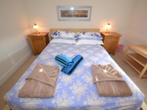 a bedroom with a bed with blue sheets and towels at The Sanctuary in Sandown