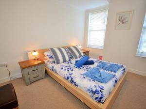 a bedroom with a bed with blue sheets and a table at The Sanctuary in Sandown