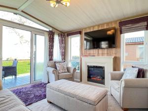 a living room with a fireplace and a tv at Knightsbridge 30 in Cameron