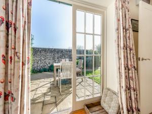 an open door to a patio with a table and chairs at Little Scarlett - Ukc6132 in Eastdean
