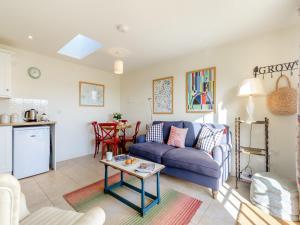 a living room with a blue couch and a table at Little Scarlett - Ukc6132 in Eastdean