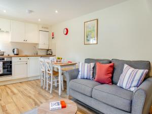 a living room with a couch and a kitchen at White Cottage - Ukc6133 in Eastdean