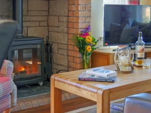 a living room with a television and a table with a fireplace at Cairngorm View - Ukc5052 in Aviemore
