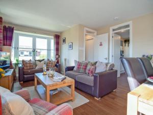 a living room with couches and a table at Cairngorm View - Ukc5052 in Aviemore +12 photos