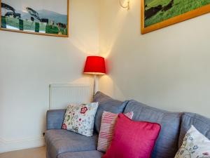 a living room with a couch with pillows and a red lamp at Beachy Barn - Ukc6126 in Eastdean