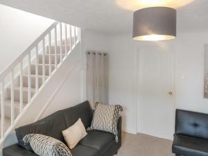 a living room with a couch and a staircase at Redcot Gardens in Stamford