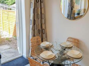 a dining room with a glass table with chairs and a mirror at Redcot Gardens in Stamford