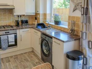 a kitchen with a sink and a washing machine at Redcot Gardens in Stamford +10 photos