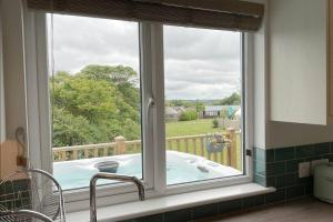 a bath tub in a window in a kitchen at Holywell - Cwc in Perranporth