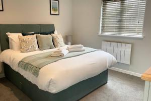 a bedroom with a large bed with white sheets and pillows at Holywell - Cwc in Perranporth