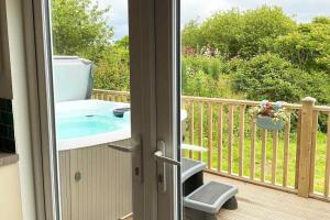 a balcony with a hot tub on a deck at Holywell - Cwc in Perranporth +15 photos