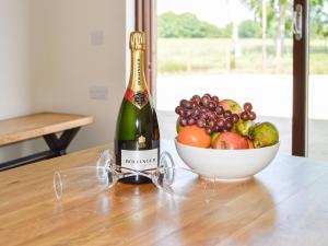 a bottle of wine next to a bowl of fruit at The Farmhouse - Ukc6250 in Linlithgow