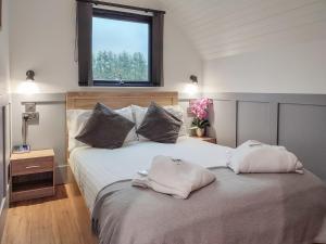 a bedroom with a large bed with two pillows on it at Meikle Balloch - Ukc6069 in Newmill