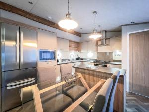 a kitchen with stainless steel appliances and wooden cabinets at Saltire 26 in St. Andrews
