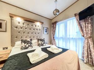 a bedroom with a large bed with towels on it at Saltire 26 in St. Andrews