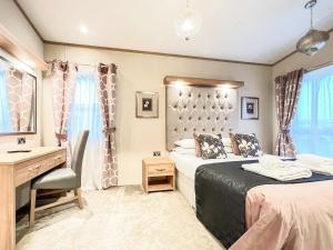 a bedroom with two beds and a desk and a sink at Saltire 26 in St. Andrews +7 photos