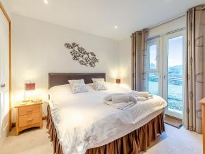 a bedroom with a large bed and a large window at 20 Mount Brioni in Downderry +4 photos