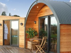 an arched extension to a wooden house with a table and chairs at Ben Rinnes - Ukc6028 in Newmill
