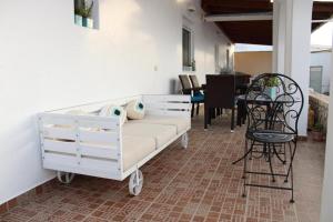 a white couch on a patio with a table and chairs at SunΚissed Suite - Pollonia Milos in Pollonia